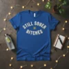 Blue t-shirt with distressed white text "STILL SOBER BITCHES" and a yellow sunburst graphic