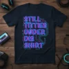 STILL TITTIES UNDER DIS SHIRT text in retro neon blue and pink on a dark t-shirt