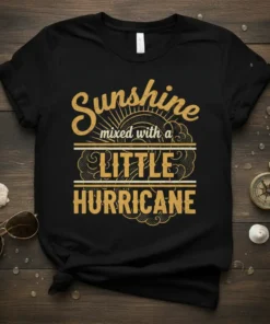 Black t-shirt with gold text reading "Sunshine mixed with a LITTLE HURRICANE" in a vintage distressed style, featuring sun and