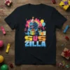 Sus Zilla text design with a blue monster in a party hat holding a gift, surrounded by balloons and presents
