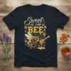 Sweet as can BEE quote with a detailed bee and honey dipper graphic on a dark t-shirt
