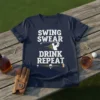 Swing Swear Drink Repeat text design with golfer graphic, golf balls, and beer mug illustration on a navy t-shirt