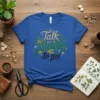 Blue t-shirt with "Talk planty to me" text in green and gold, surrounded by leaves and flowers