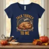 Talk Turkey To Me quote with a roasted turkey graphic on a navy blue t-shirt, perfect for Thanksgiving
