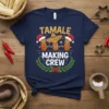 Tamale Making Crew text with cartoon tamales wearing Santa hats and a sombrero on a navy t-shirt