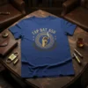 Blue t-shirt with "TAP DAT ASH" text and a vintage graphic of a hand holding a smoking cigar, surrounded by
