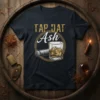 Tap Dat Ash t-shirt design featuring a cigar and a glass of whiskey, with distressed gold text