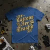 Tattoos Are Trashy text design with skull and roses on a blue t-shirt