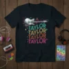 Retro t-shirt design featuring "Taylor Taylor Taylor Taylor" repeated in colorful stacked text with a dynamic electric guitar graphic above