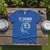 Blue t-shirt with white text "TE CALMAS o te calmo" and a cartoon illustration of a sassy abuela holding a
