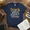 Navy t-shirt with gold and white text "Teach LOVE love INSPIRE" in a decorative font, designed for teachers