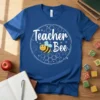 Teacher Bee t-shirt design with a cute cartoon bee and honeycomb pattern, white text on a blue shirt
