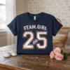 Navy t-shirt with "Team Girl 25" text and pink floral accents, perfect for gender reveal parties