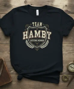 Team Hamby Lifetime Member text on a black t-shirt, featuring a shield emblem and laurel wreath