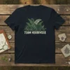 Team Herbivore t-shirt design featuring two dinosaurs, a Brachiosaurus and a Triceratops, surrounded by ferns and foliage