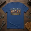 Team Hicks Lifetime Member text design with rustic, industrial font and gear accents on a blue t-shirt