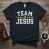 Team Jesus text graphic on a navy blue t-shirt, featuring white distressed collegiate style font