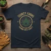 Navy t-shirt with gold text "Tegrity Farms Farming With Tergity" and a central cannabis leaf emblem