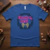 Blue t-shirt featuring the "thank u, next" text in neon pink, surrounded by a thorny rose wreath and golden angel