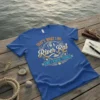 Blue t-shirt with "THAT'S WHAT I DO I'M A River Rat AND I KNOW THINGS" text and fishing-themed graphics
