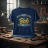 The Best The Original Bob The Man The Legend quote on a dark blue t-shirt with metallic gold and blue