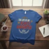 Blue t-shirt with gold stars and red glitter text reading "The Life of an Eldest Daughter" and a crown graphic