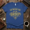 The Mature One Of The Group quote in gold distressed font on a blue t-shirt with a compass graphic