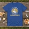 The Mighty Honkers design on a blue t-shirt, featuring a white goose wearing a hat with wavy water below