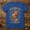 The Read More Cow Is A Wise Cow text with a cute highland cow reading a book on a stack