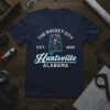 Navy blue t-shirt featuring "The Rocket City Est. 1805 Huntsville Alabama" text with a rocket graphic inside an outline of