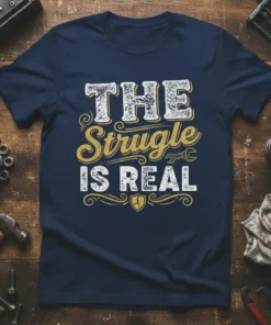 The Struggle Is Real quote in distressed white and gold typography on a navy t-shirt, with wrench graphic