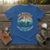 The Wild Calls Explore the Unknown t-shirt with a bear and mountain graphic in a vintage sunset circle