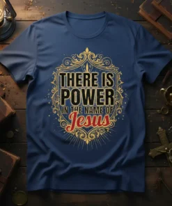There Is Power In The Name Of Jesus quote on a navy t-shirt with ornate gold border and red "Jesus"