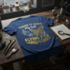 Navy blue t-shirt with gold text "THERE IT GOES My last FLYING F*CK" and a steampunk-inspired butterfly and robotic hand