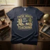 Navy t-shirt with gold text "THESE BOOTS are made for TEACHING," featuring cowboy boots, books, and a cactus graphic