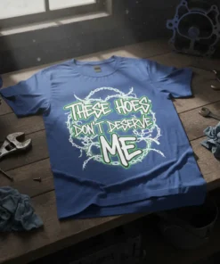 Blue t-shirt with "THESE HOES DON'T DESERVE ME" text in green and white, surrounded by barbed wire graphic