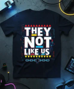Bold white text reading "THEY NOT LIKE US" on a black t-shirt with geometric red, yellow, and blue accents