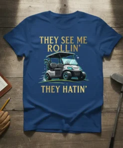 Golf cart t-shirt with gold text "THEY SEE ME ROLLIN' THEY HATIN'" and a graphic of a golf cart