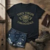 Thick Thighs Thin Patience quote on a black t-shirt with a shield and axe graphic