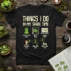Black t-shirt with "Things I Do In My Spare Time" design, illustrating frog-related activities like hanging out, looking at, researching
