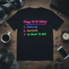 Black t-shirt with neon-colored text listing "Things To Do Today: Wake Up, Survive, Go Back To Bed" for a humorous