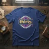 Thirty. birthday t-shirt with gold glitter text inside a gold rectangle, set against a gear graphic with neon accents