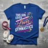 Blue t-shirt with "This Girl Loves Gymnastics" text and gymnastics equipment graphics, including rings and a balance beam
