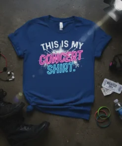 Blue t-shirt with "THIS IS MY CONCERT SHIRT." text in neon pink and blue, featuring a crowd graphic and spotlights