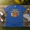 Royal blue t-shirt with "THIS IS MY Grilling Shirt" text, featuring a grill, beer, and utensils graphic