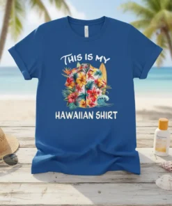 Blue t-shirt with white text "THIS IS MY HAWAIIAN SHIRT" above a vibrant floral graphic of a Hawaiian shirt, surfboard