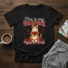 Black t-shirt with "This is my VALENTINE Pajama Shirt" text and a cute cat holding a rose basket, surrounded by