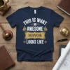 Navy t-shirt with white text: "THIS IS WHAT AN AWESOME MAYOR LOOKS LIKE", featuring thumbs-up graphics and a golden banner