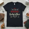 This Is What An Incredible Godmother Looks Like text design on a black t-shirt, featuring red hearts and cream-colored typography