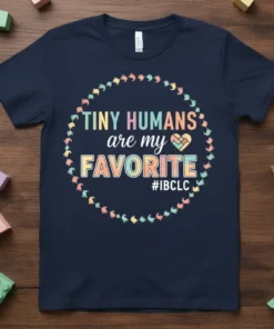 Navy blue t-shirt with colorful text "TINY HUMANS are my FAVORITE #IBCLC" surrounded by a circle of baby footprints